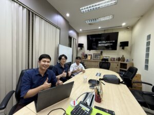 ผู้เรียนนั่งที่โต๊ะประชุมยาวพร้อมแล็ปท็อปในห้องอบรม