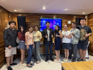 ภาพหมู่ผู้เรียนหน้าจอสอนในห้องเรียนผนังไม้